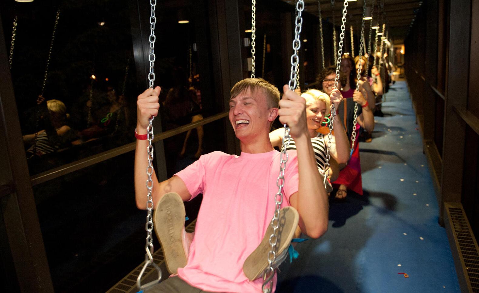 Students on swings in skyway during an event